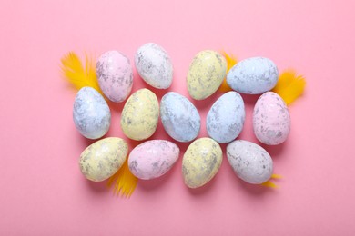 Photo of Many painted Easter eggs on pink background, flat lay