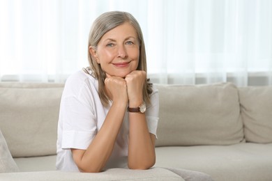 Photo of Portrait of beautiful senior woman on sofa at home. Space for text