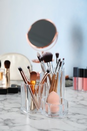 Photo of Organizer with beauty accessories on dressing table. Space for text