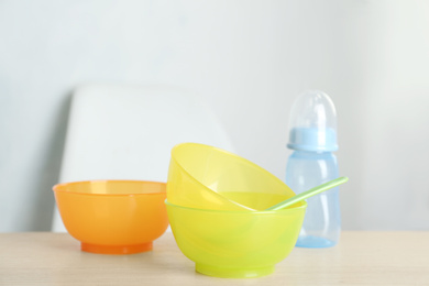 Set of plastic dishware on wooden table indoors. Serving baby food