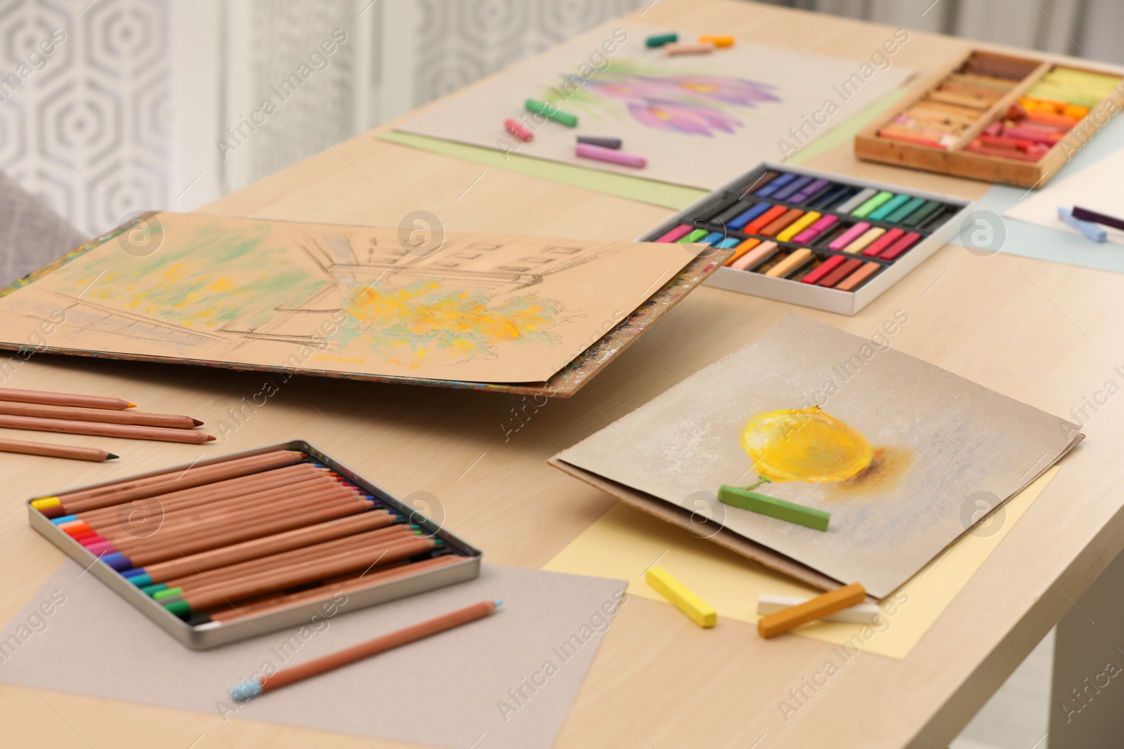 Photo of Artist's workplace with drawings, soft pastels and color pencils on table