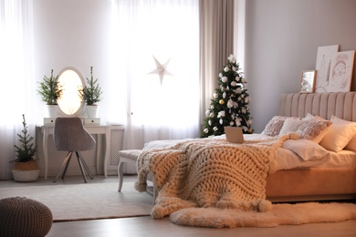 Beautiful decorated Christmas tree in bedroom interior