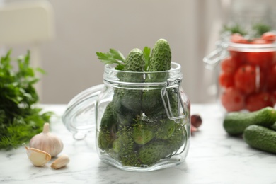 Photo of Pickling jar with fresh cucumbers on white marble table