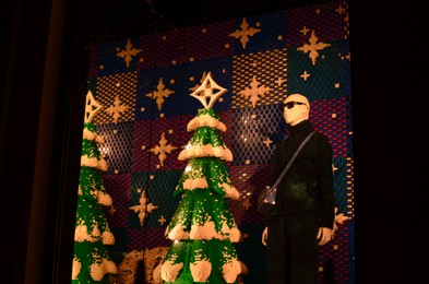 Photo of Paris, France - December 10, 2022: Fashion store display with men's clothes and plastic Christmas tree