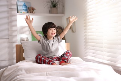 Photo of Happy little boy on bed at home
