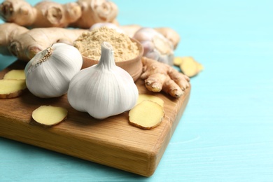 Photo of Ginger and fresh garlic on light blue wooden table, space for text. Natural cold remedies