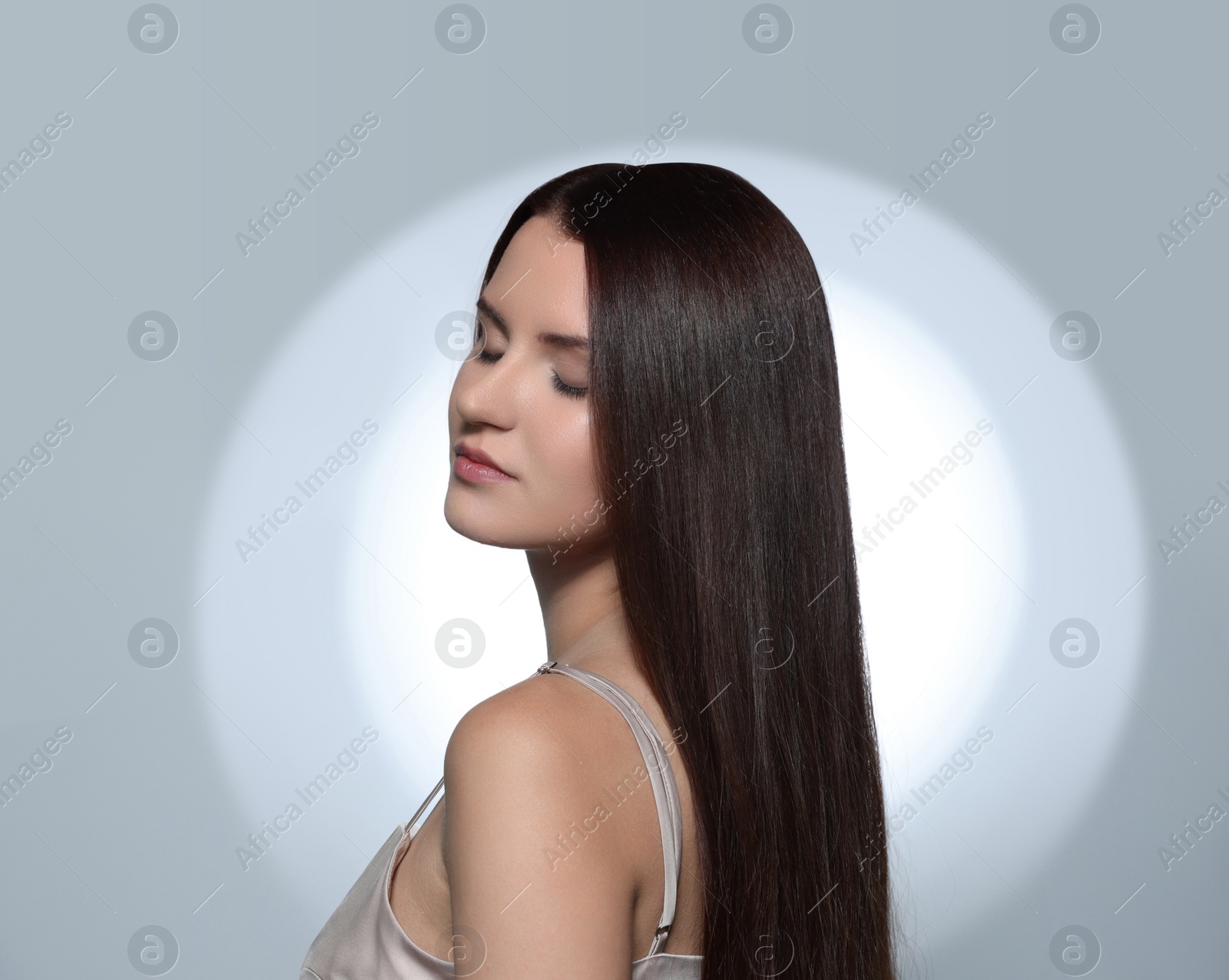 Photo of Beautiful young woman with healthy strong hair posing in studio