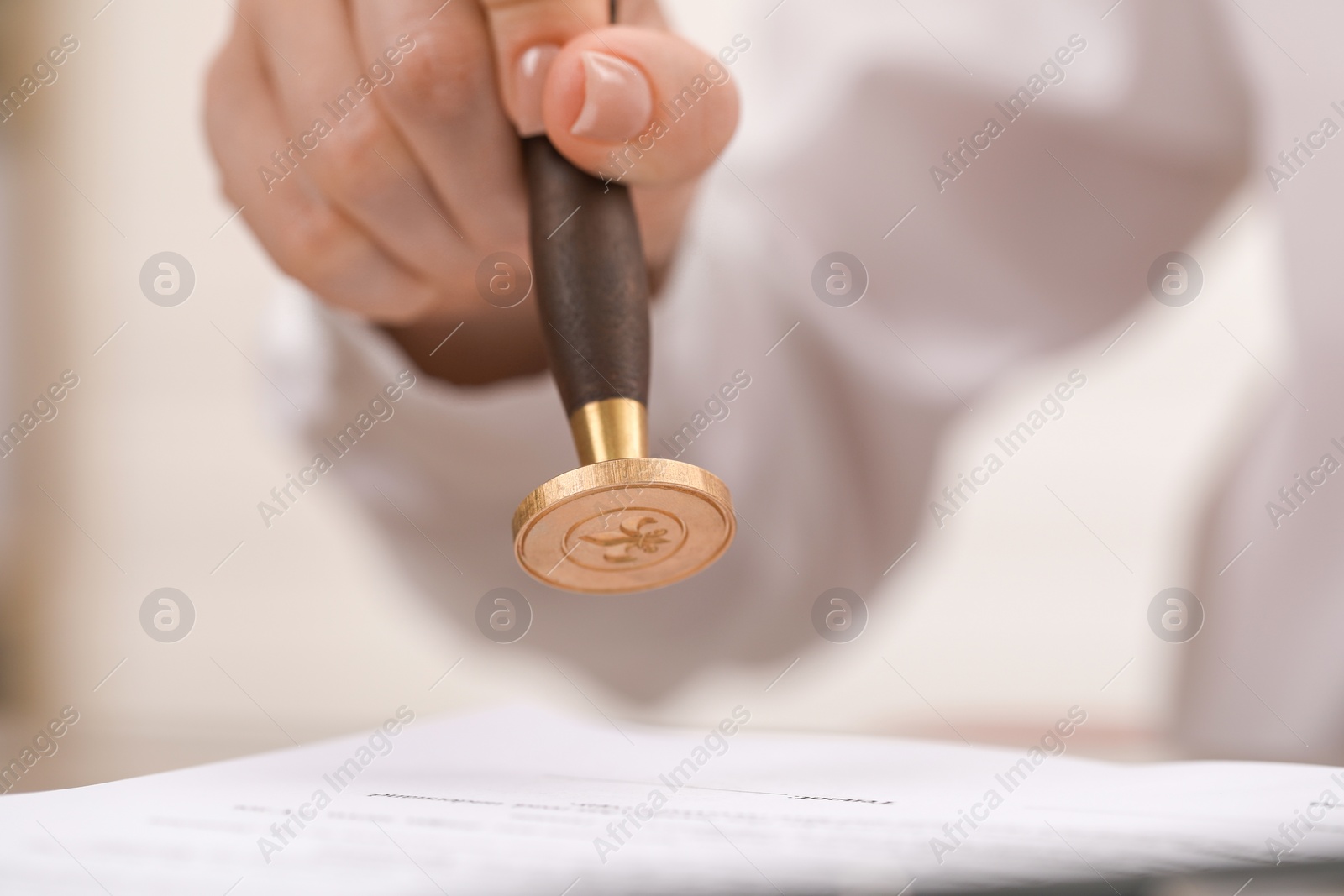 Photo of Woman stamping document at table, closeup view