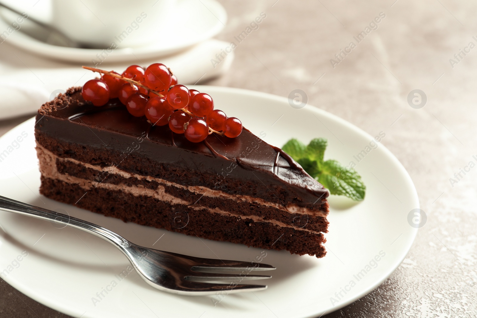 Photo of Plate with slice of tasty chocolate cake and fork on table