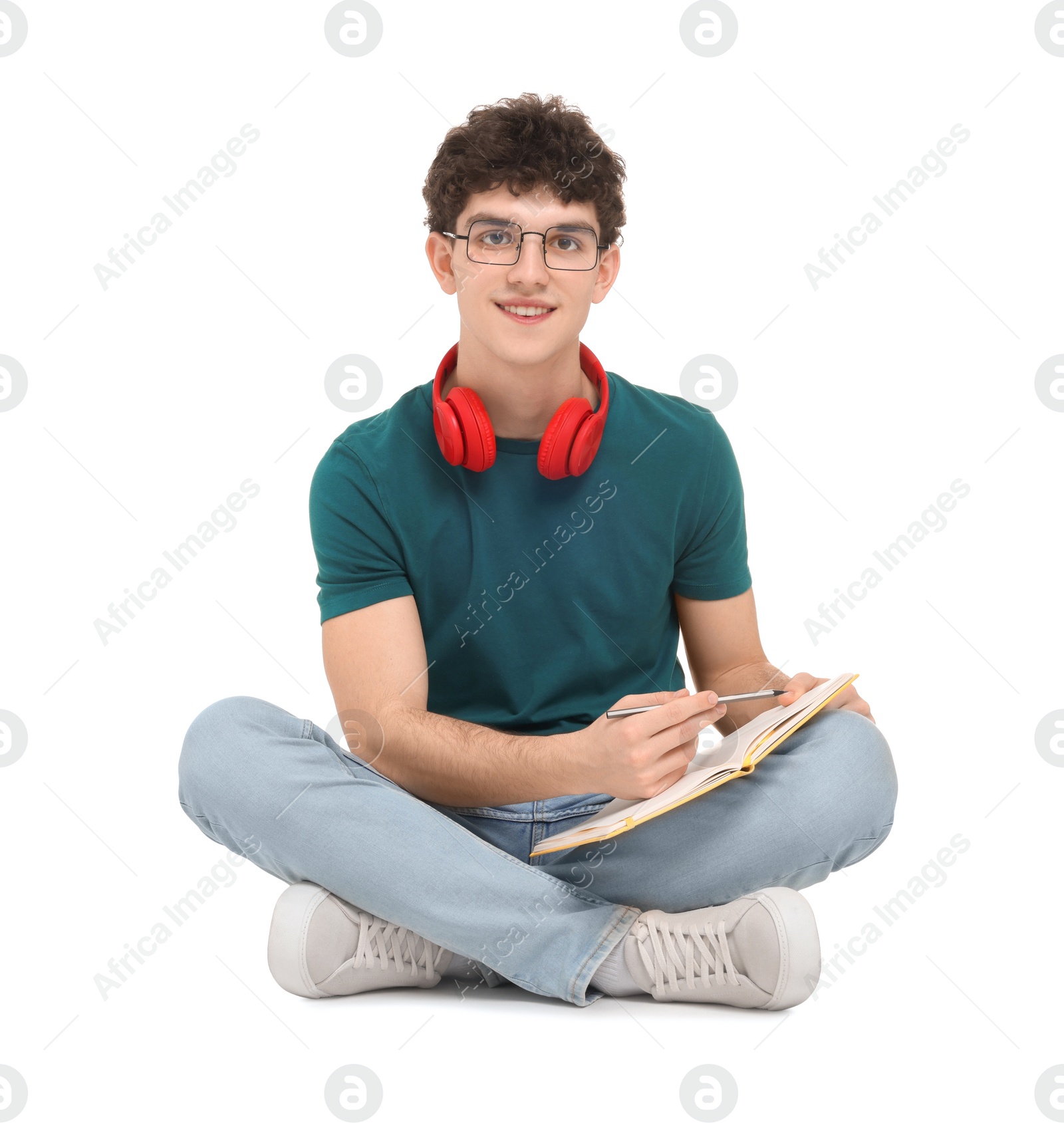 Photo of Portrait of student with notebook and headphones sitting on white background