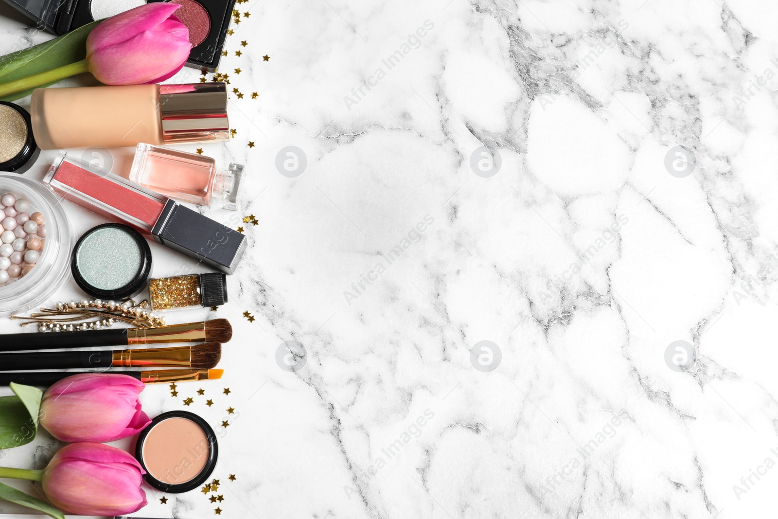 Photo of Makeup products and flowers on marble background, flat lay with space for text