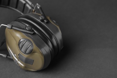 Tactical headphones on black background, closeup with space for text. Military training equipment