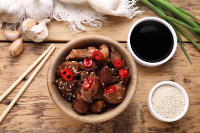Tasty roasted meat, soy sauce and products on wooden table, flat lay