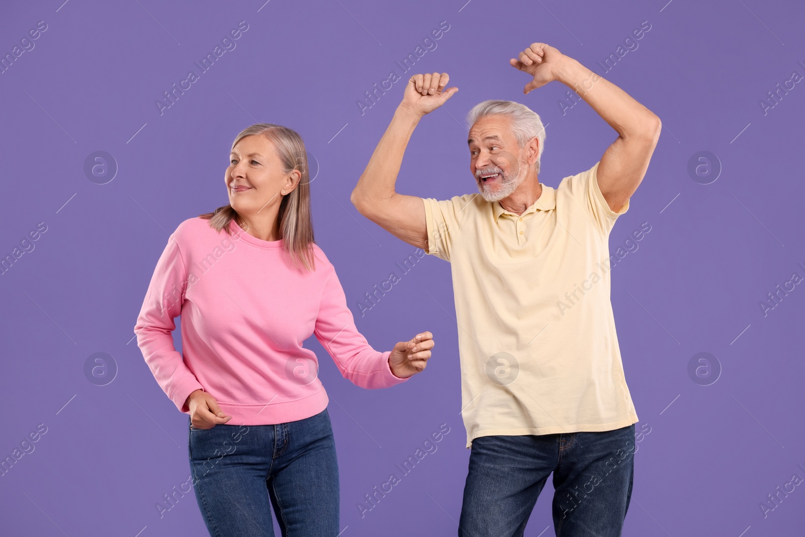 Photo of Senior couple dancing together on purple background