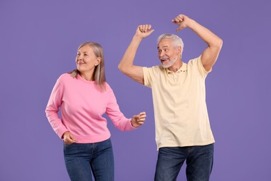 Photo of Senior couple dancing together on purple background