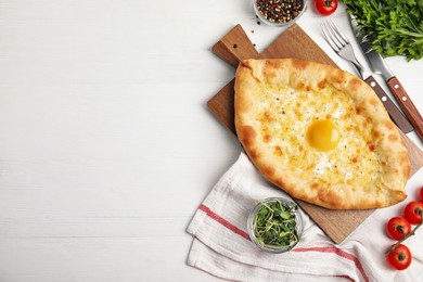 Photo of Fresh delicious Adjarian khachapuri served on white wooden table, flat lay. Space for text