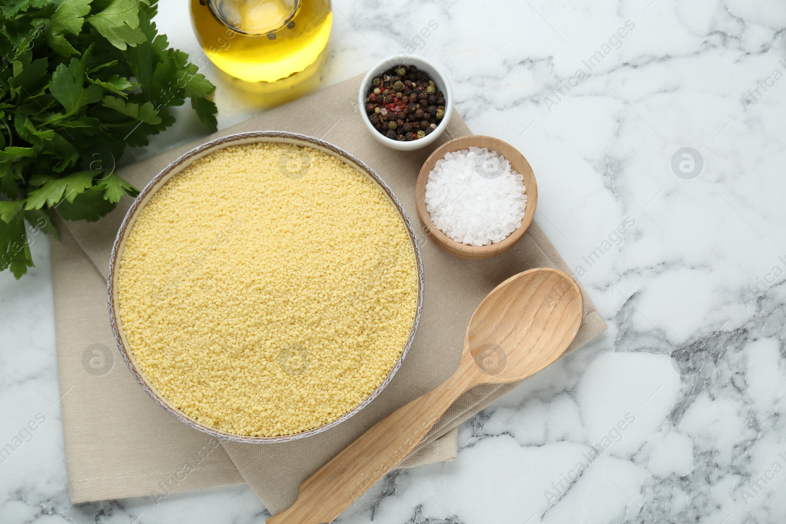 Photo of Raw couscous and ingredients on white marble table, flat lay. Space for text