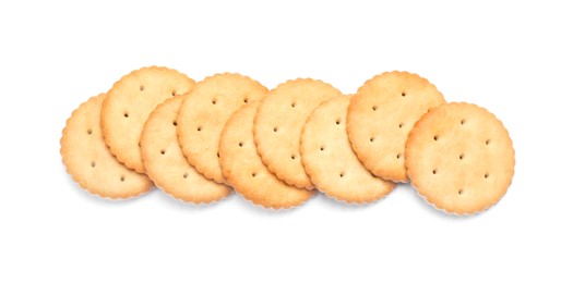 Many crispy crackers isolated on white, top view. Delicious snack