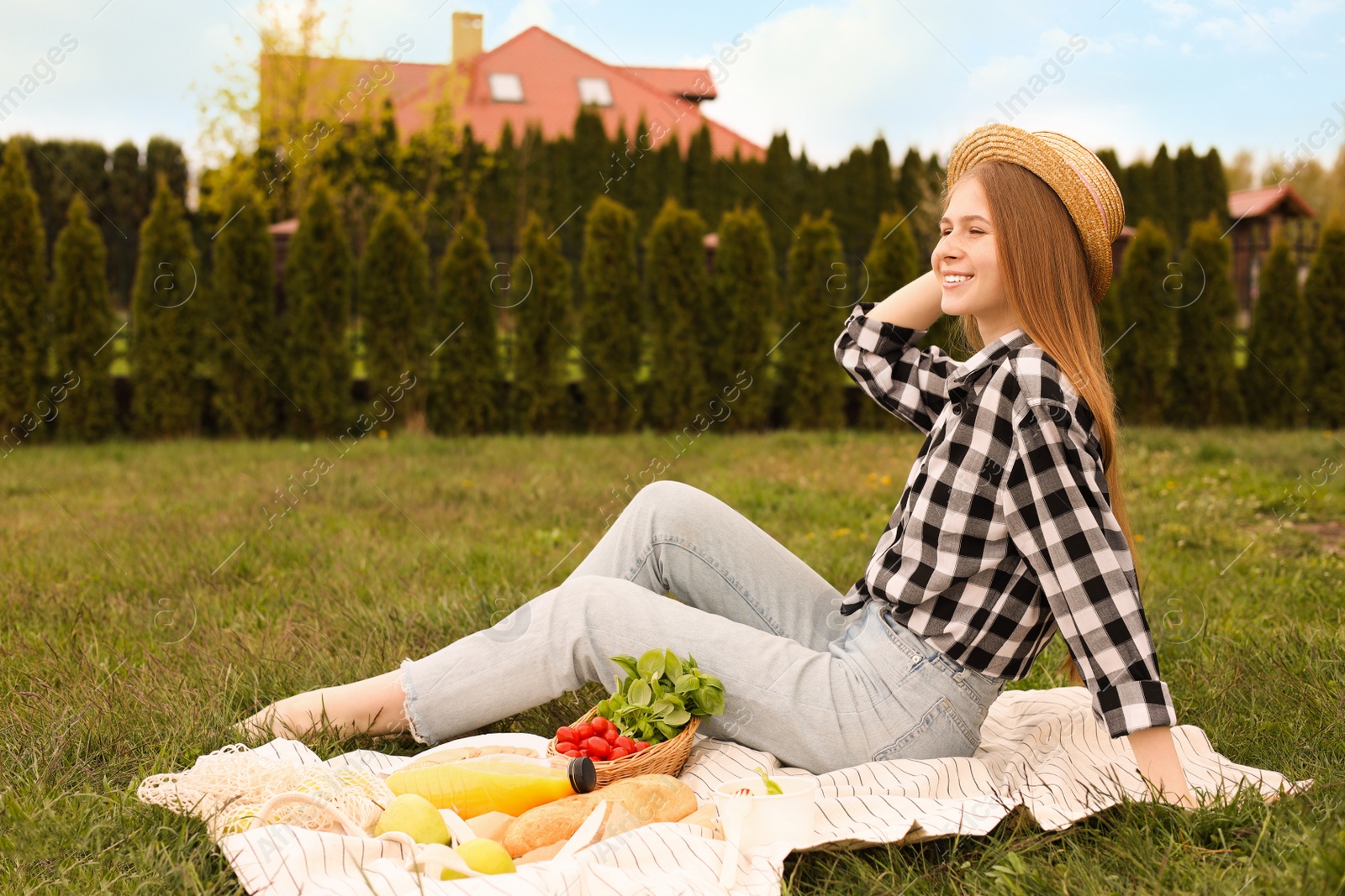 Photo of Happy girl having picnic on green grass in park