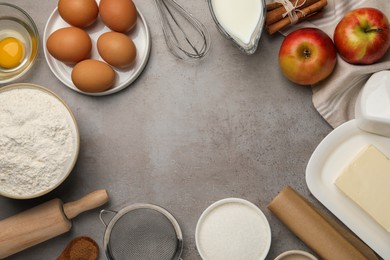 Photo of Flat lay composition with flour, butter and different ingredients on grey table, space for text. Cooking yeast cake