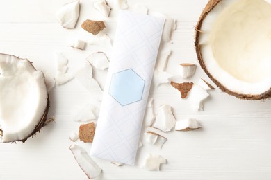 Scented sachet and coconut on white wooden table, flat lay