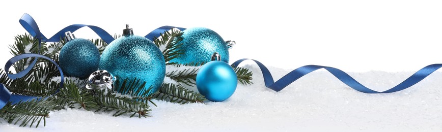 Beautiful light blue Christmas balls, fir tree branch and ribbon on snow against white background