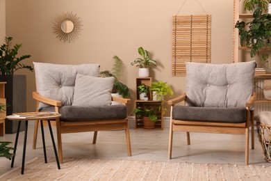 Photo of Lounge area interior with comfortable armchairs and beautiful houseplants
