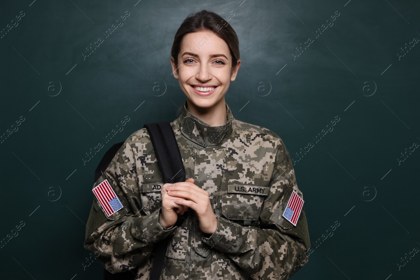 Photo of Female cadet with backpack near chalkboard. Military education