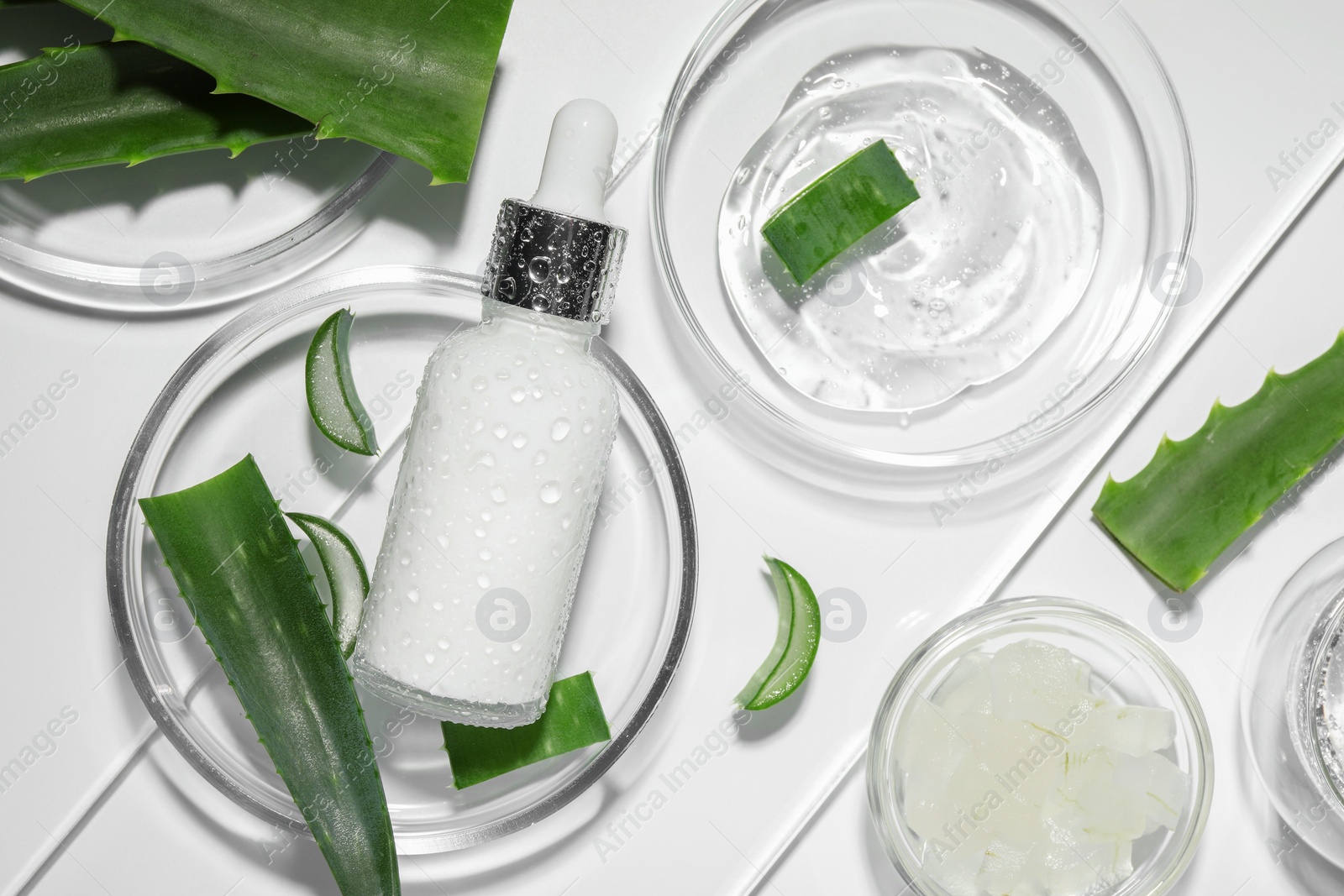 Photo of Flat lay composition with cosmetic products and cut aloe vera on white background