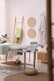 Comfortable massage table with clean towels in spa center