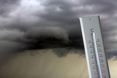 Image of Autumn or spring weather. Thermometer against thundercloud
