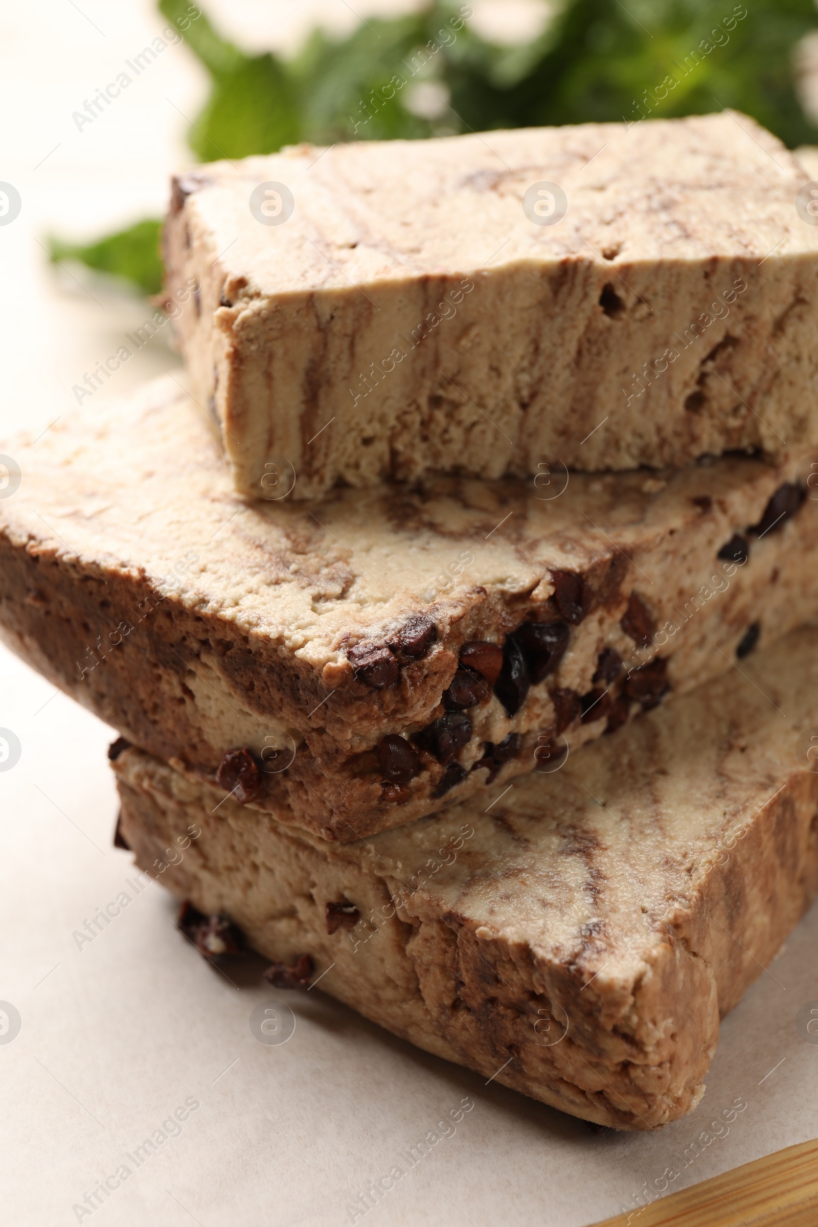 Photo of Pieces of tasty chocolate halva on table, closeup