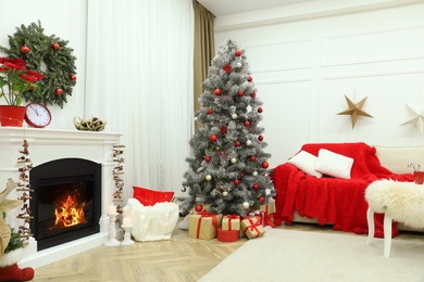 Beautiful living room interior with burning fireplace and Christmas tree