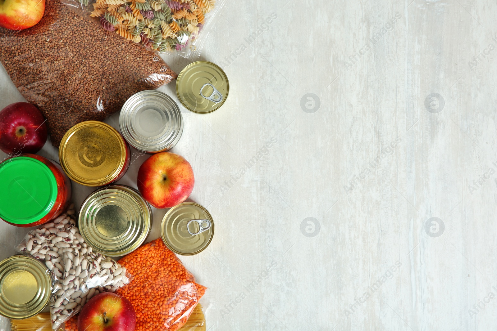 Photo of Many different products and space for text on white wooden background, flat lay. Food donation