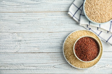 Flat lay composition with different types of rice and space for text on wooden table