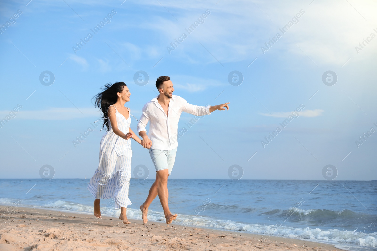 Photo of Happy young couple running together on beach