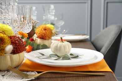 Beautiful autumn table setting. Plates, cutlery, glasses and floral decor