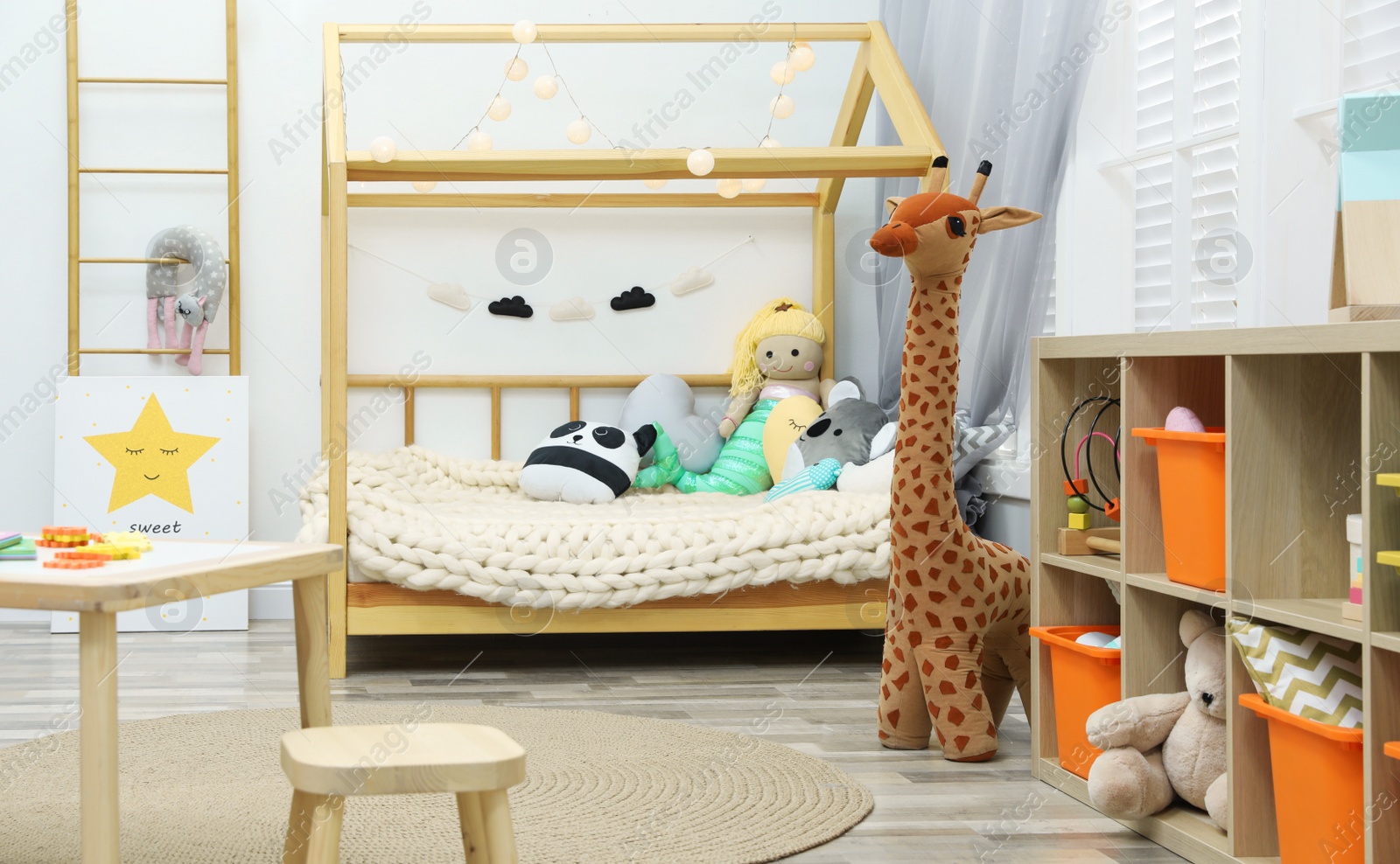 Photo of Cute child's room interior with toys and wooden furniture