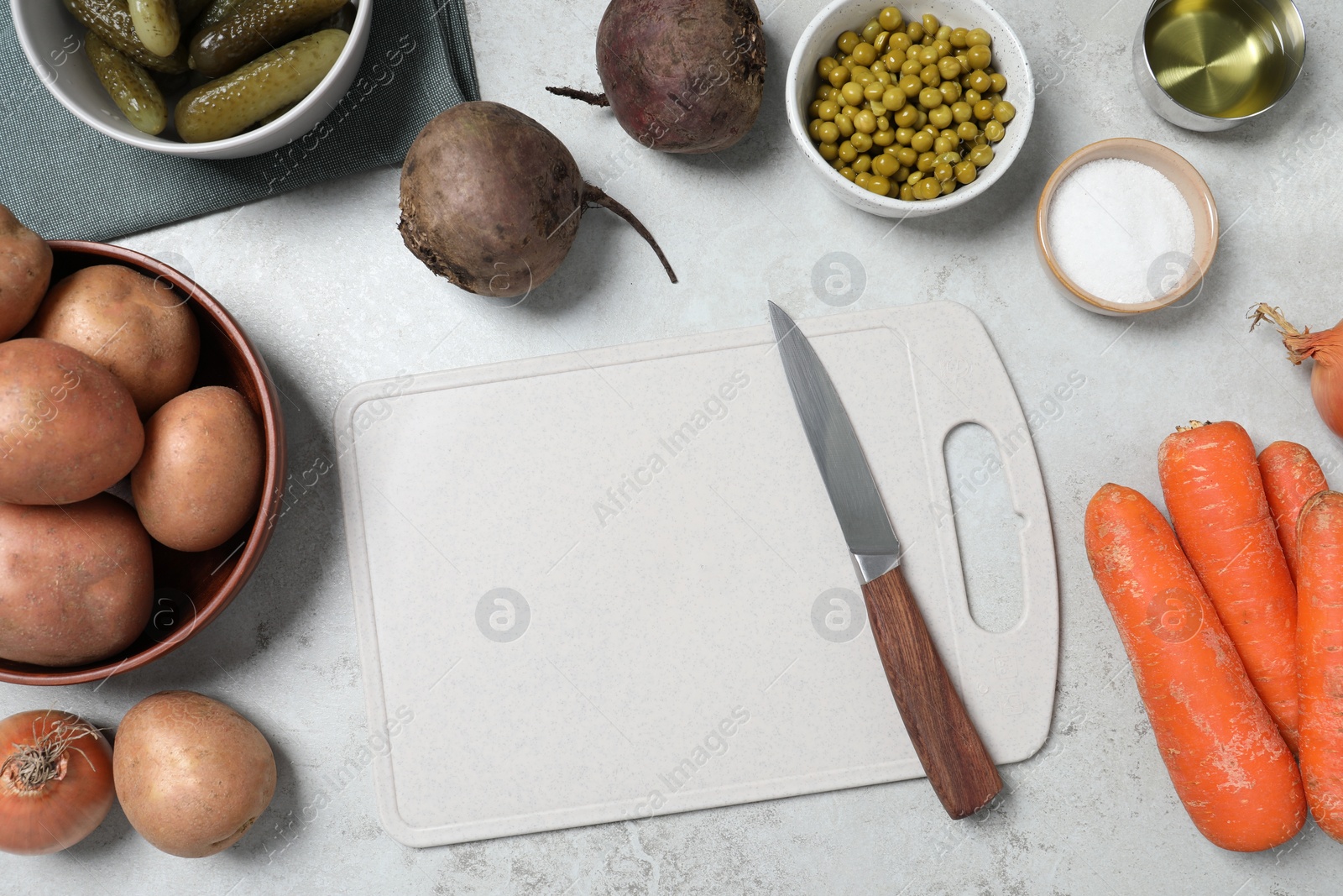 Photo of Many fresh vegetables and other ingredients on white table, flat lay. Cooking vinaigrette salad