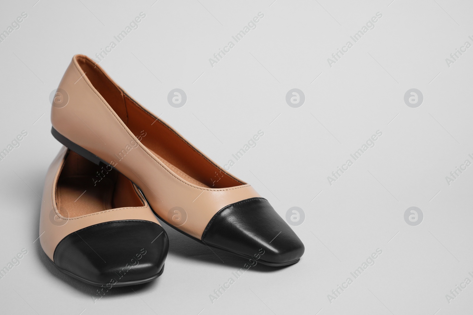 Photo of Pair of new stylish square toe ballet flats on light grey background. Space for text