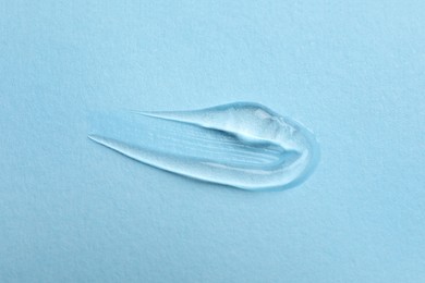 Swatch of cosmetic gel on light blue background, top view