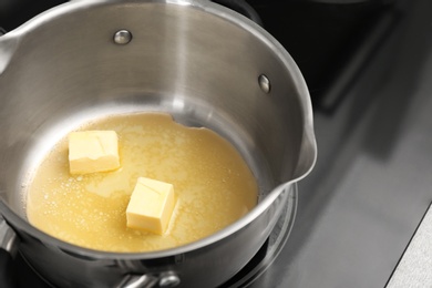 Saucepan with melting butter on electric stove, closeup