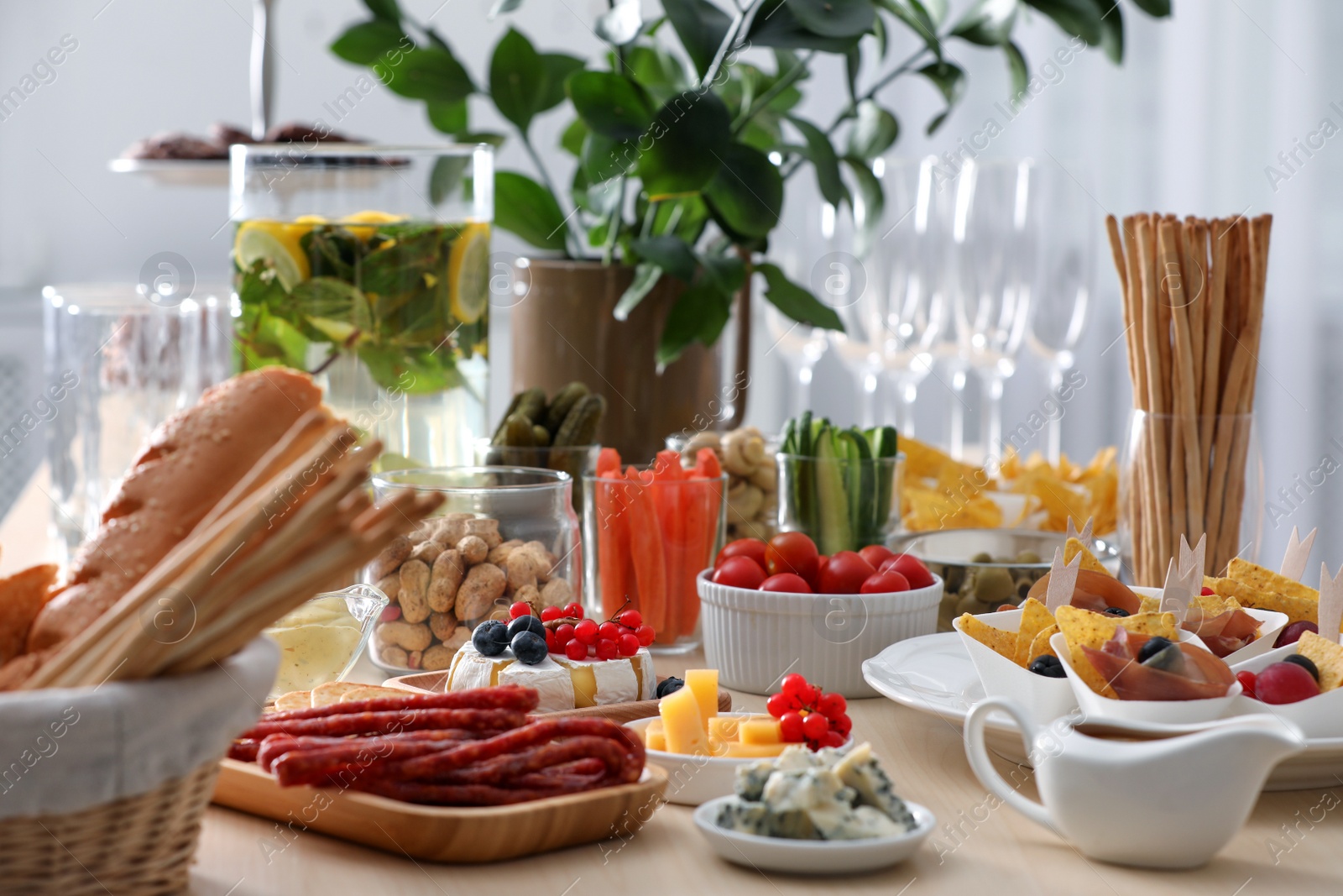 Photo of Variety of snacks on wooden table in buffet style indoors