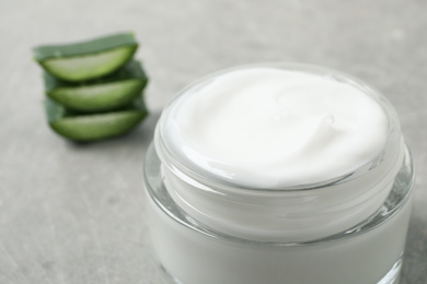 Open jar of aloe cream on grey table, closeup. Organic cosmetics