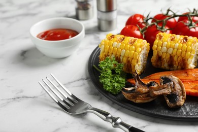 Delicious grilled vegetables served on white marble table, closeup