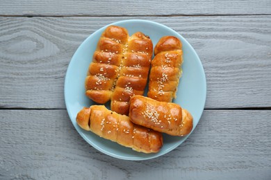Photo of Delicious sausage rolls on grey wooden table, top view