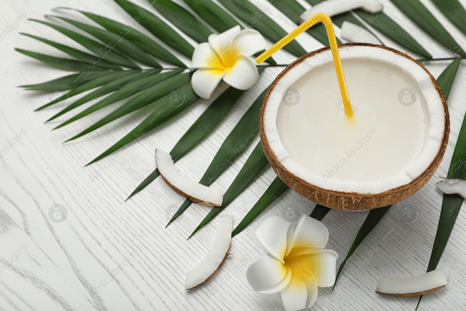 Photo of Composition with half of coconut on white wooden background