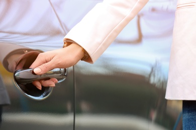 Photo of Closeup view of woman opening car door