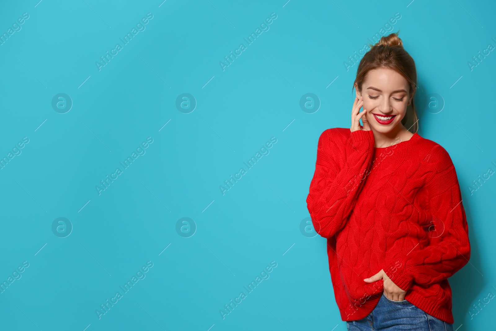 Photo of Beautiful young woman in warm sweater on color background. Space for text