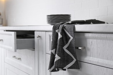 Photo of Clean grey towel hanging on kitchen counter
